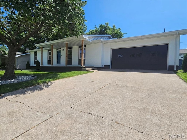 23 Hamlin Heights Dr, Hannibal, MO 63401 - ranch-style home with driveway, a garage, a front yard, stucco siding, and covered porch