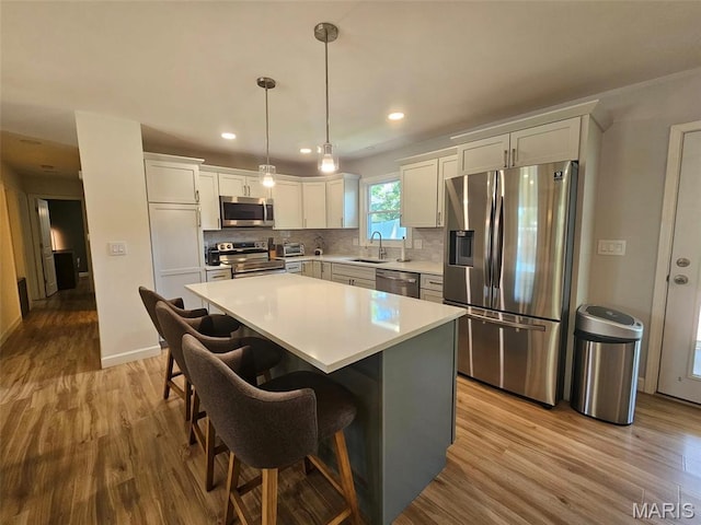 23 Hamlin Heights Dr, Hannibal, MO 63401 - kitchen featuring stainless steel appliances, wood finished floors, backsplash, a center island, and recessed lighting