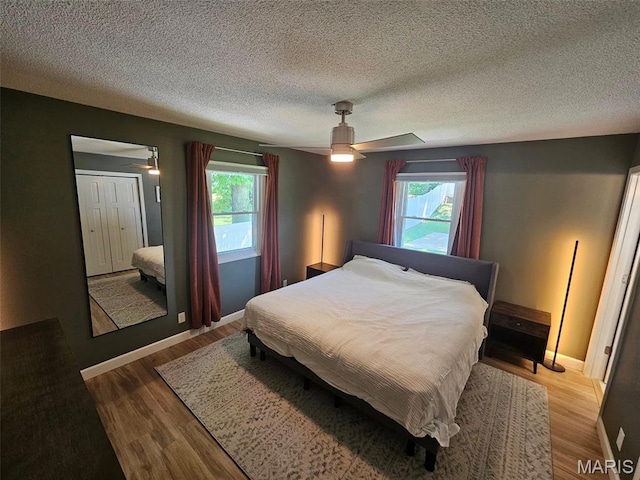23 Hamlin Heights Dr, Hannibal, MO 63401 - bedroom with multiple windows, a textured ceiling, light wood-style flooring, and ceiling fan