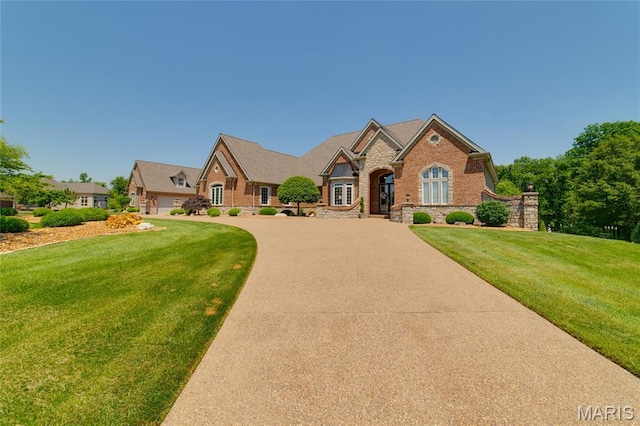 204 Logans Ct, Foristell, MO 63348 - view of front of home with stone siding, a front yard, concrete driveway, and brick siding