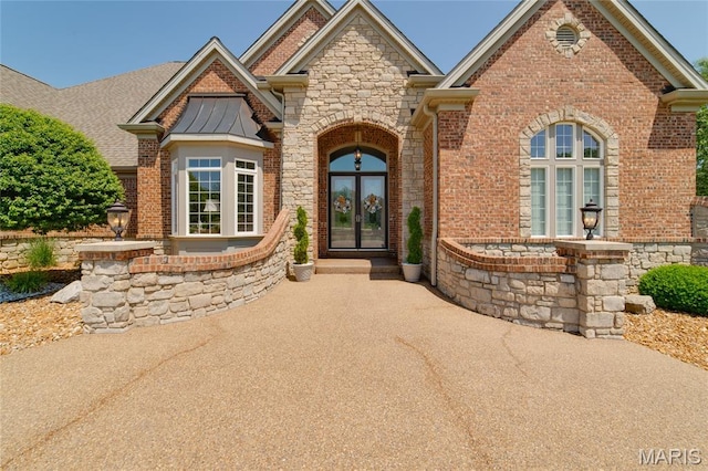 204 Logans Ct, Foristell, MO 63348 - view of front of house featuring french doors, stone siding, and brick siding
