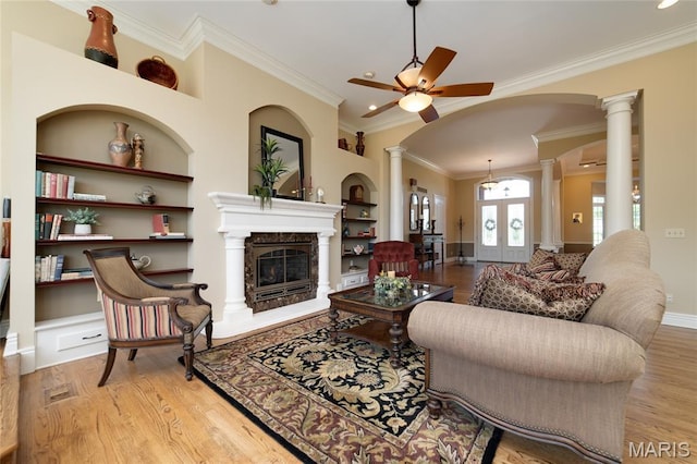 204 Logans Ct, Foristell, MO 63348 - living room featuring decorative columns, ceiling fan, built in shelves, wood finished floors, and ornamental molding