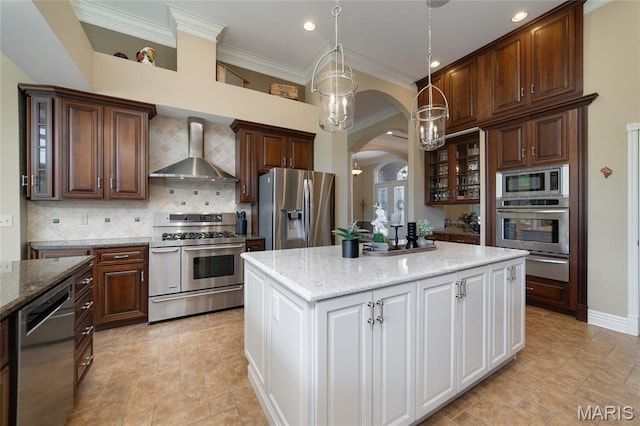 204 Logans Ct, Foristell, MO 63348 - kitchen featuring wall chimney exhaust hood, appliances with stainless steel finishes, arched walkways, crown molding, and a center island