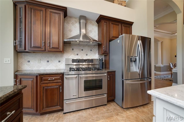 204 Logans Ct, Foristell, MO 63348 - kitchen featuring appliances with stainless steel finishes, wall chimney exhaust hood, ornamental molding, dark stone countertops, and arched walkways
