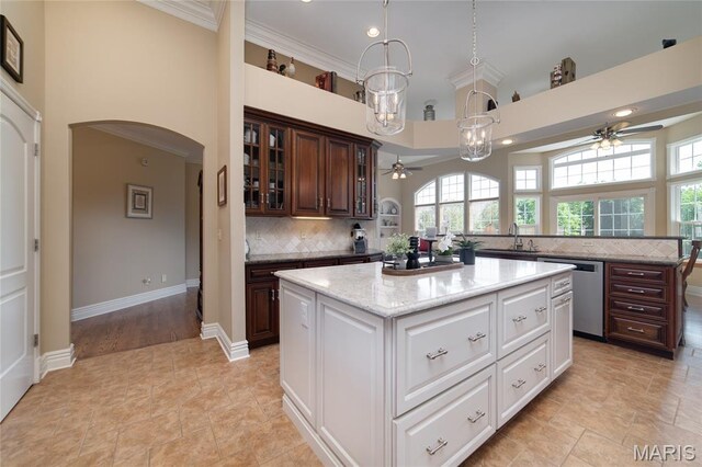 204 Logans Ct, Foristell, MO 63348 - kitchen with ceiling fan, stainless steel dishwasher, a towering ceiling, a center island, and arched walkways
