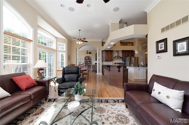 204 Logans Ct, Foristell, MO 63348 - living room featuring a ceiling fan, crown molding, arched walkways, light wood-style floors, and decorative columns