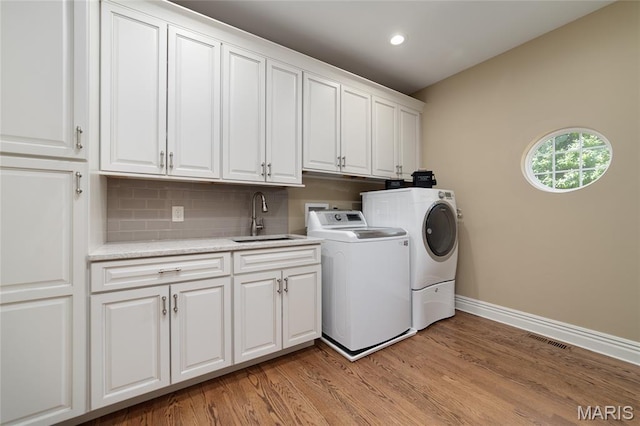 204 Logans Ct, Foristell, MO 63348 - laundry room featuring washer and clothes dryer, cabinet space, light wood-type flooring, and recessed lighting