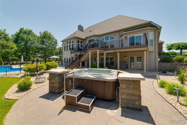 204 Logans Ct, Foristell, MO 63348 - rear view of house with a hot tub, a patio area, stairway, a deck, and a chimney
