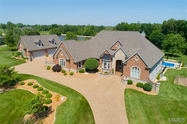 204 Logans Ct, Foristell, MO 63348 - view of front facade with curved driveway, stone siding, a front lawn, and a chimney