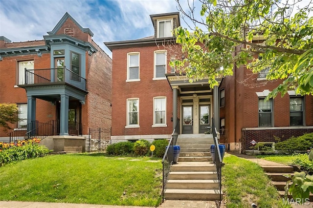 3822 Humphrey St, Saint Louis, MO 63116 - view of front of house with brick siding, a front lawn, a balcony, and french doors