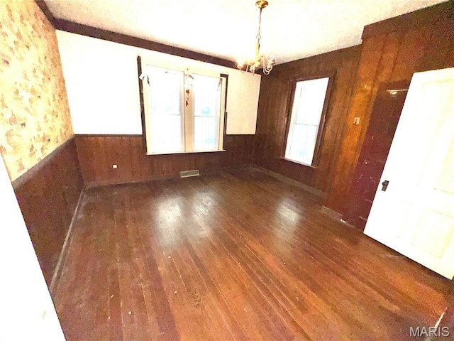 1112 Center St, Bismarck, MO 63624 - unfurnished dining area featuring hardwood / wood-style floors, a chandelier, wooden walls, and a wainscoted wall