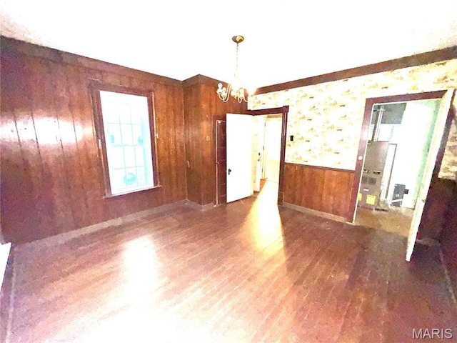 1112 Center St, Bismarck, MO 63624 - unfurnished room featuring a chandelier, wooden walls, wood finished floors, and wainscoting