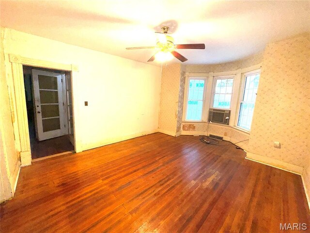 1112 Center St, Bismarck, MO 63624 - spare room with wood finished floors, wallpapered walls, cooling unit, and a ceiling fan