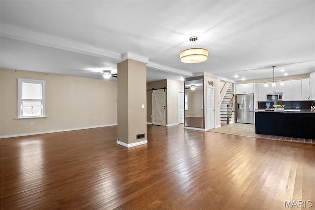 19 N 31st St N, Belleville, IL 62226 - unfurnished living room with a barn door, stairs, hardwood / wood-style floors, and a ceiling fan