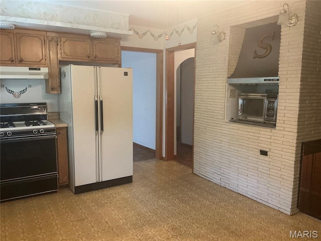 211 Edgar St, Gillespie, IL 62033 - kitchen featuring gas range, freestanding refrigerator, under cabinet range hood, arched walkways, and light floors