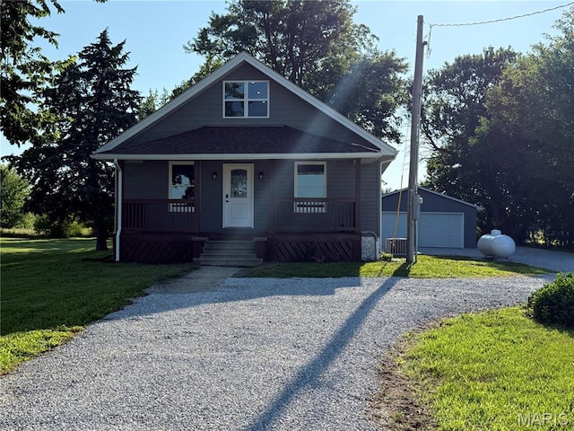6596 County Road 263, Hannibal, MO 63401 - bungalow-style home with an outbuilding, a front yard, covered porch, driveway, and a garage