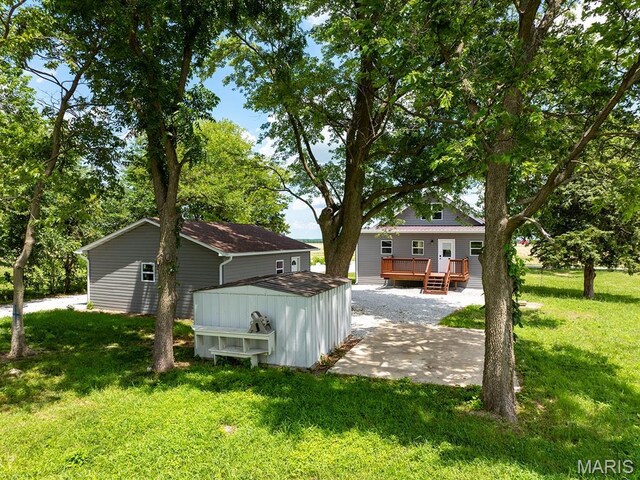 6596 County Road 263, Hannibal, MO 63401 - view of grassy yard featuring a deck, a patio, and an outdoor structure