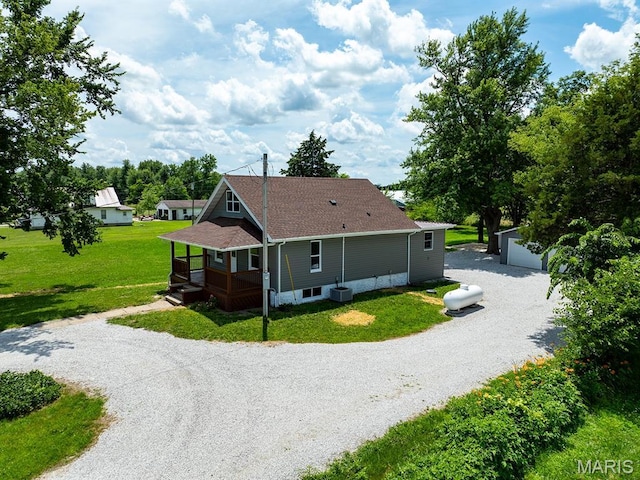 6596 County Road 263, Hannibal, MO 63401 - view of side of home with an outdoor structure, a lawn, covered porch, a shingled roof, and driveway