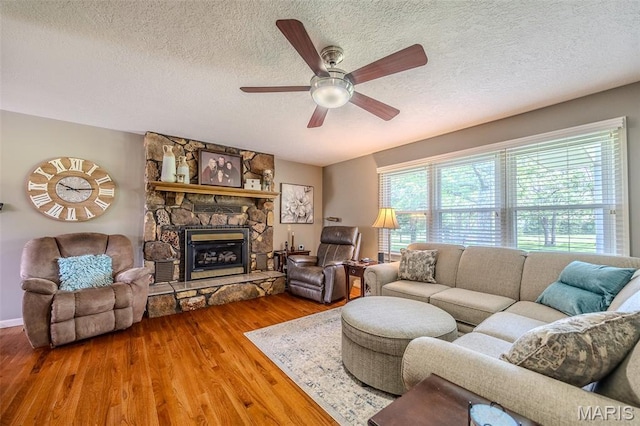 16930 Grace Rd, Lebanon, MO 65536 - living room with wood finished floors, a ceiling fan, a textured ceiling, and a fireplace