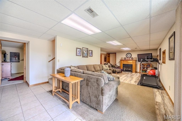 16930 Grace Rd, Lebanon, MO 65536 - living area with a drop ceiling, a fireplace, stairway, and light tile patterned flooring