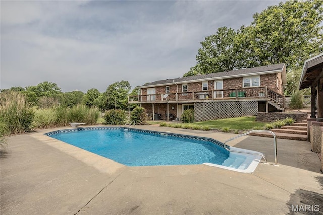 16930 Grace Rd, Lebanon, MO 65536 - outdoor pool featuring stairs, a wooden deck, a patio, a lawn, and a diving board