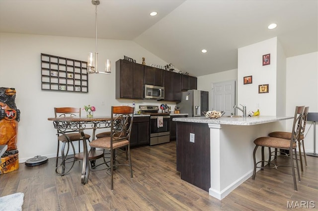 8280 Obrien Dr, Cedar Hill, MO 63016 - kitchen with stainless steel appliances, lofted ceiling, dark brown cabinetry, a kitchen bar, and dark wood-style floors