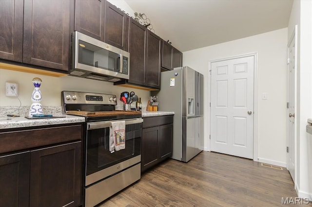8280 Obrien Dr, Cedar Hill, MO 63016 - kitchen featuring stainless steel appliances, dark brown cabinetry, dark wood finished floors, and light stone counters