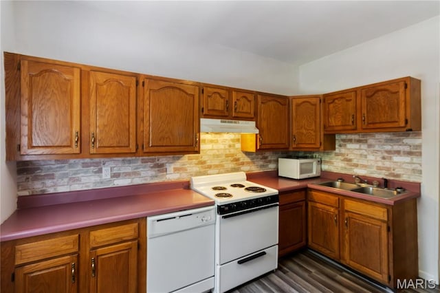 1009 S 3rd St, De Soto, MO 63020 - kitchen with white appliances, under cabinet range hood, brown cabinetry, and backsplash