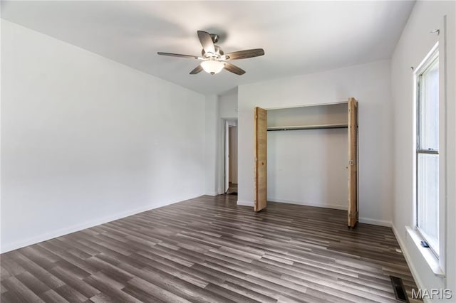 1009 S 3rd St, De Soto, MO 63020 - unfurnished bedroom with dark wood-style flooring, a closet, and multiple windows