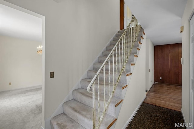 7849 Cassia Ct, Saint Louis, MO 63123 - staircase featuring wooden walls and a chandelier