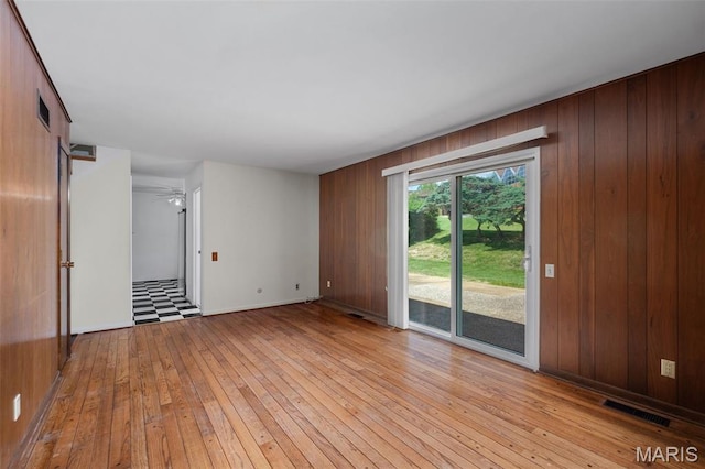 7849 Cassia Ct, Saint Louis, MO 63123 - spare room featuring light wood-style floors and wooden walls