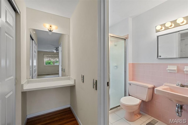 7849 Cassia Ct, Saint Louis, MO 63123 - full bathroom featuring a shower stall, tile walls, ceiling fan, tile patterned floors, and wainscoting