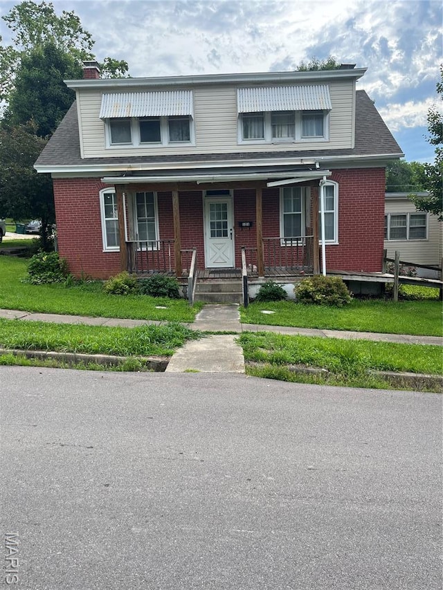 121 N 13th St, Louisiana, MO 63353 - view of front facade with brick siding, covered porch, and a chimney