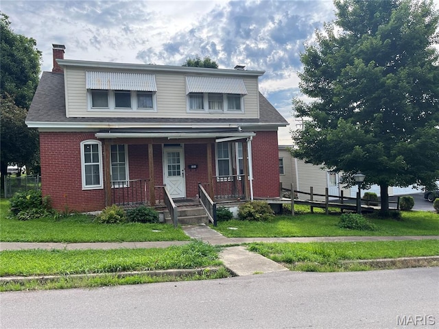121 N 13th St, Louisiana, MO 63353 - view of front of house with brick siding, a chimney, covered porch, and a front lawn