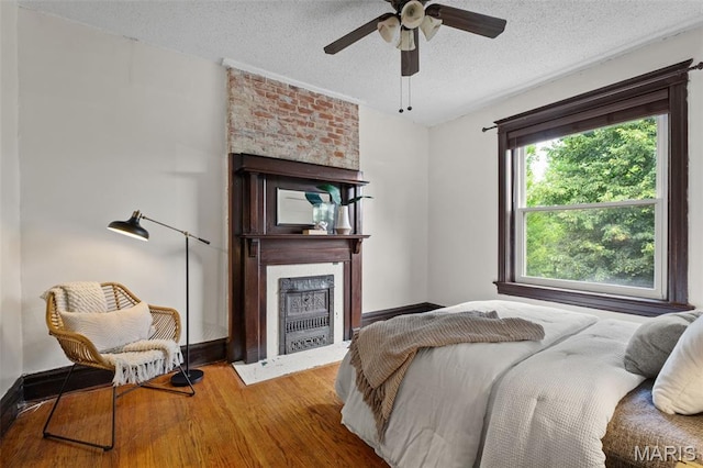 2929 Victor St, Saint Louis, MO 63104 - bedroom featuring a fireplace, wood finished floors, a textured ceiling, and ceiling fan