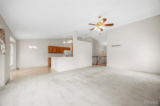 2749 Samuel Dr Unit 736A, Dardenne Prairie, MO 63368 - unfurnished living room with light colored carpet, vaulted ceiling, a ceiling fan, and a chandelier