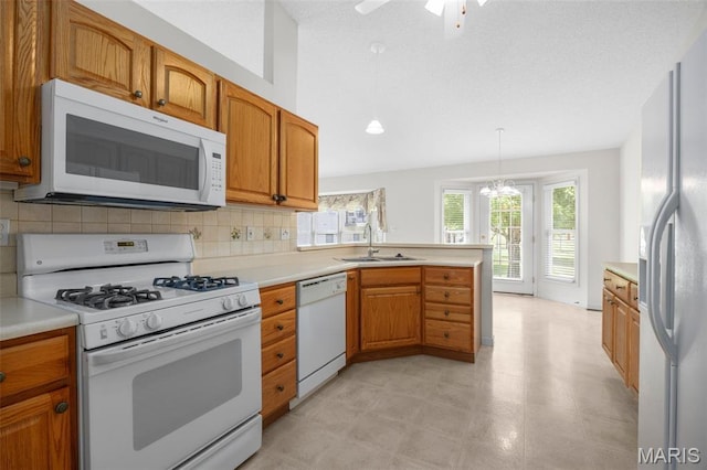 2749 Samuel Dr Unit 736A, Dardenne Prairie, MO 63368 - kitchen featuring white appliances, backsplash, light countertops, a peninsula, and brown cabinets