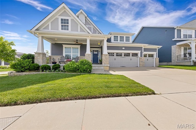 2308 Sand Cherry Dr, Wildwood, MO 63011 - craftsman-style home with stone siding, a porch, driveway, a front yard, and a garage