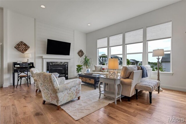 2308 Sand Cherry Dr, Wildwood, MO 63011 - living area featuring light wood-type flooring, a glass covered fireplace, and recessed lighting
