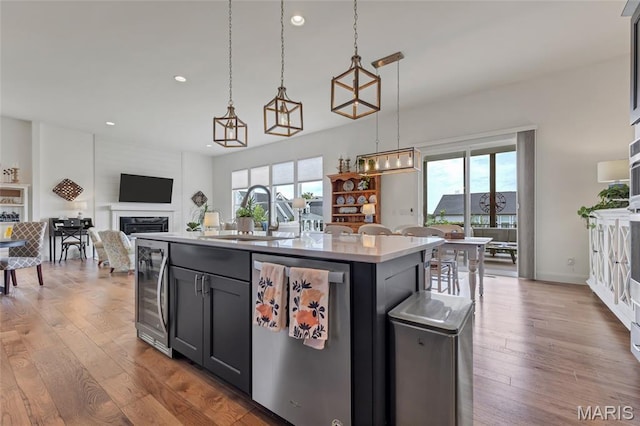 2308 Sand Cherry Dr, Wildwood, MO 63011 - kitchen featuring wine cooler, stainless steel dishwasher, recessed lighting, a fireplace, and light countertops