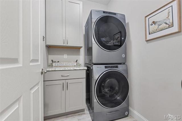 2308 Sand Cherry Dr, Wildwood, MO 63011 - washroom featuring estacked washer and dryer, cabinet space, and light wood-style floors