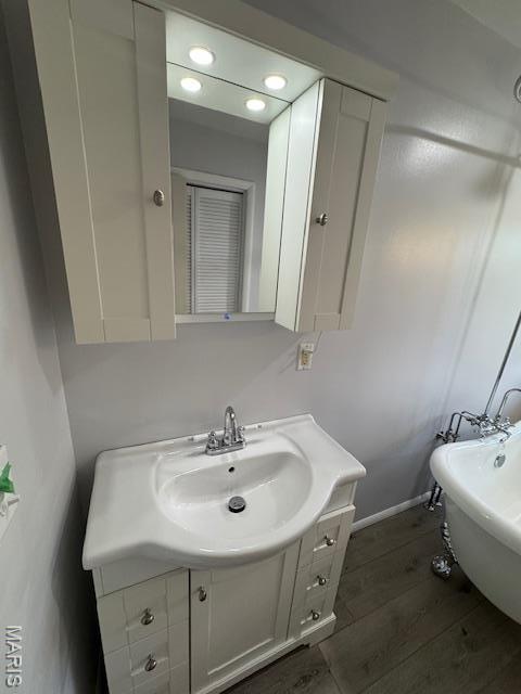 618 Houston Rd, Rolla, MO 65401 - full bathroom featuring vanity, a soaking tub, wood finished floors, and recessed lighting