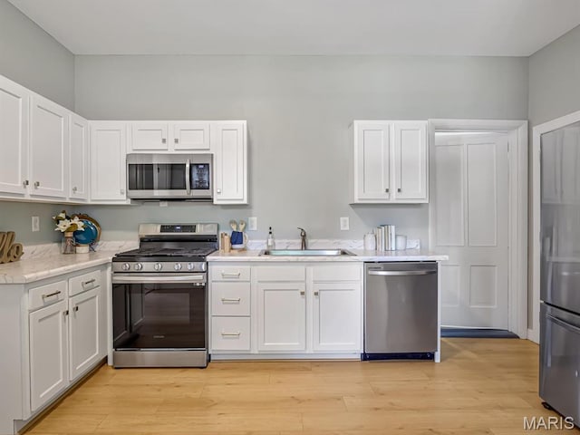 1734 Seminary St, Alton, IL 62002 - kitchen featuring appliances with stainless steel finishes, light countertops, white cabinets, and light wood-style flooring