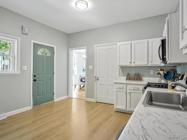 1734 Seminary St, Alton, IL 62002 - kitchen featuring light wood-style floors, white cabinets, and stainless steel microwave