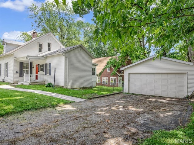 1734 Seminary St, Alton, IL 62002 - view of property exterior featuring a porch, a detached garage, a chimney, an outdoor structure, and a lawn