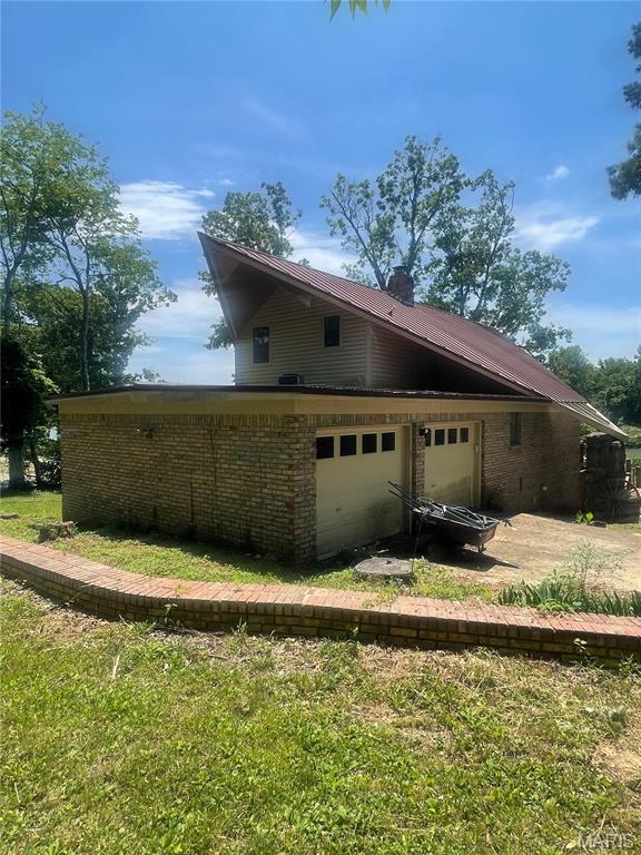 252 Trails End Way, Doniphan, MO 63935 - back of house with brick siding, a metal roof, and driveway