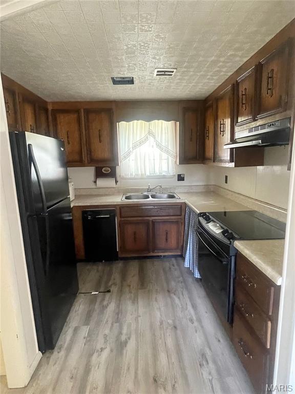 252 Trails End Way, Doniphan, MO 63935 - kitchen with black appliances, under cabinet range hood, light wood-type flooring, an ornate ceiling, and light countertops