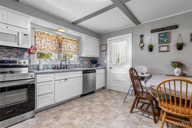 39 Pine St, Farmington, MO 63640 - kitchen featuring appliances with stainless steel finishes, backsplash, white cabinetry, and light stone countertops