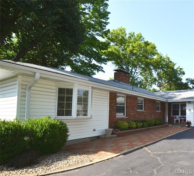 1406 Marshall Rd, Kirkwood, MO 63122 - ranch-style home featuring a chimney, brick siding, and a patio area