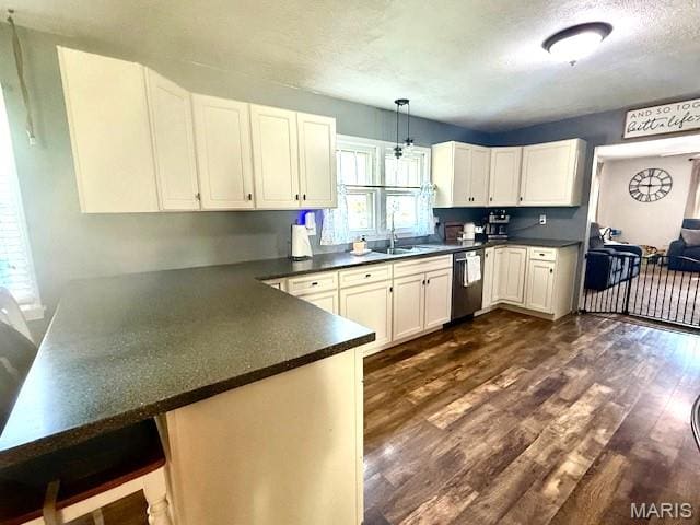 902 Sycamore St, Germantown, IL 62245 - kitchen with stainless steel dishwasher, dark countertops, a peninsula, dark wood-style flooring, and white cabinets